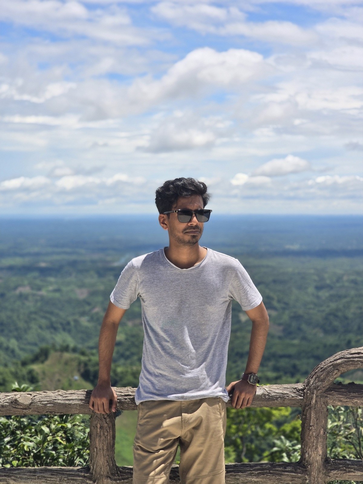 Standing on a wooden ridge overlooking a green valley